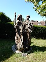 A photo showing a sculpture in oak of two medieval pilgrims.